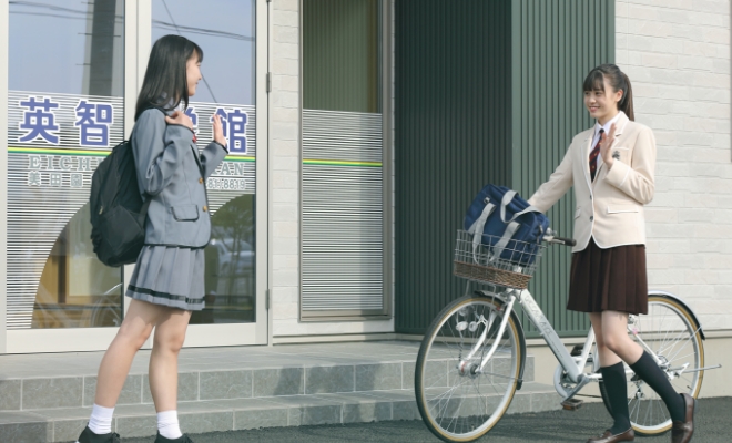 登校する女子学生と出迎え